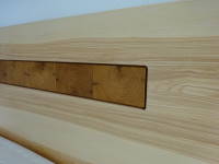 Massivholzbett aus Esche - die Einlage am Kopfteil sowie die Schublade an der Nachtkonsole sind aus Hirnholz
